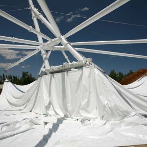 Imagen de una estructura tensada de color blanco que cubre la terraza de un camping